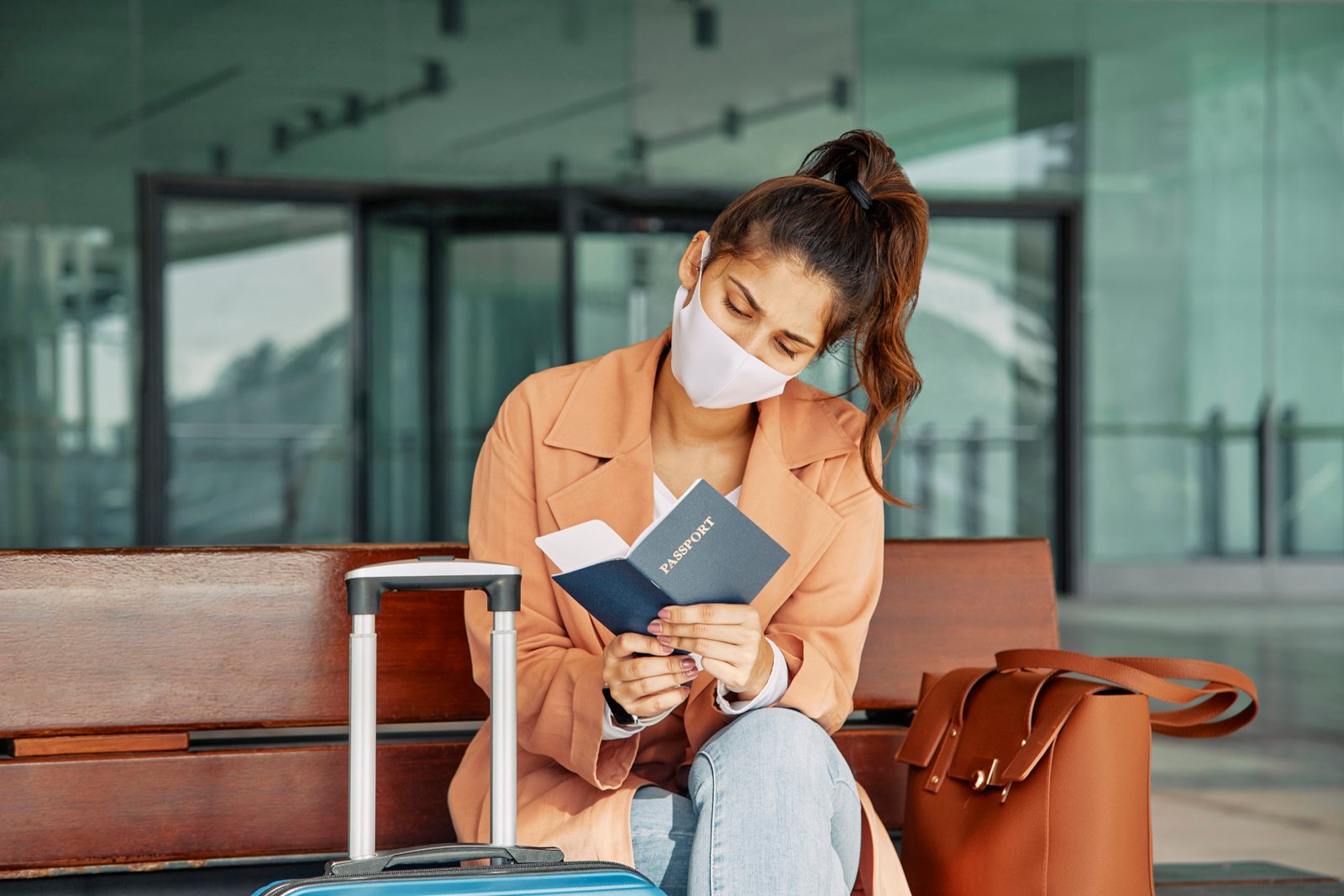 woman-with-medical-mask-checking-her-passport-airport-during-pandemic (1)